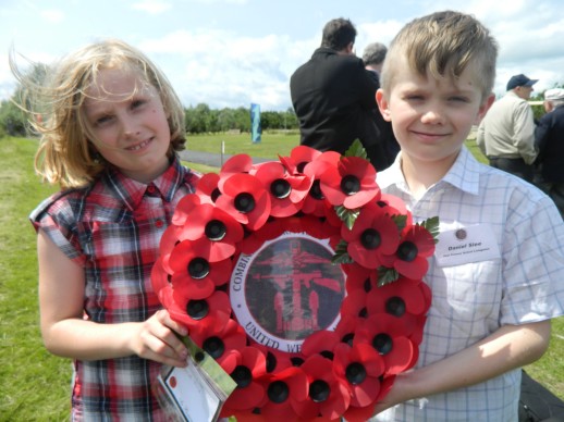 Michelle and Daniel Slee, grear grandchildren of John Glen laying a wreath at the memorial dedication ceremony.